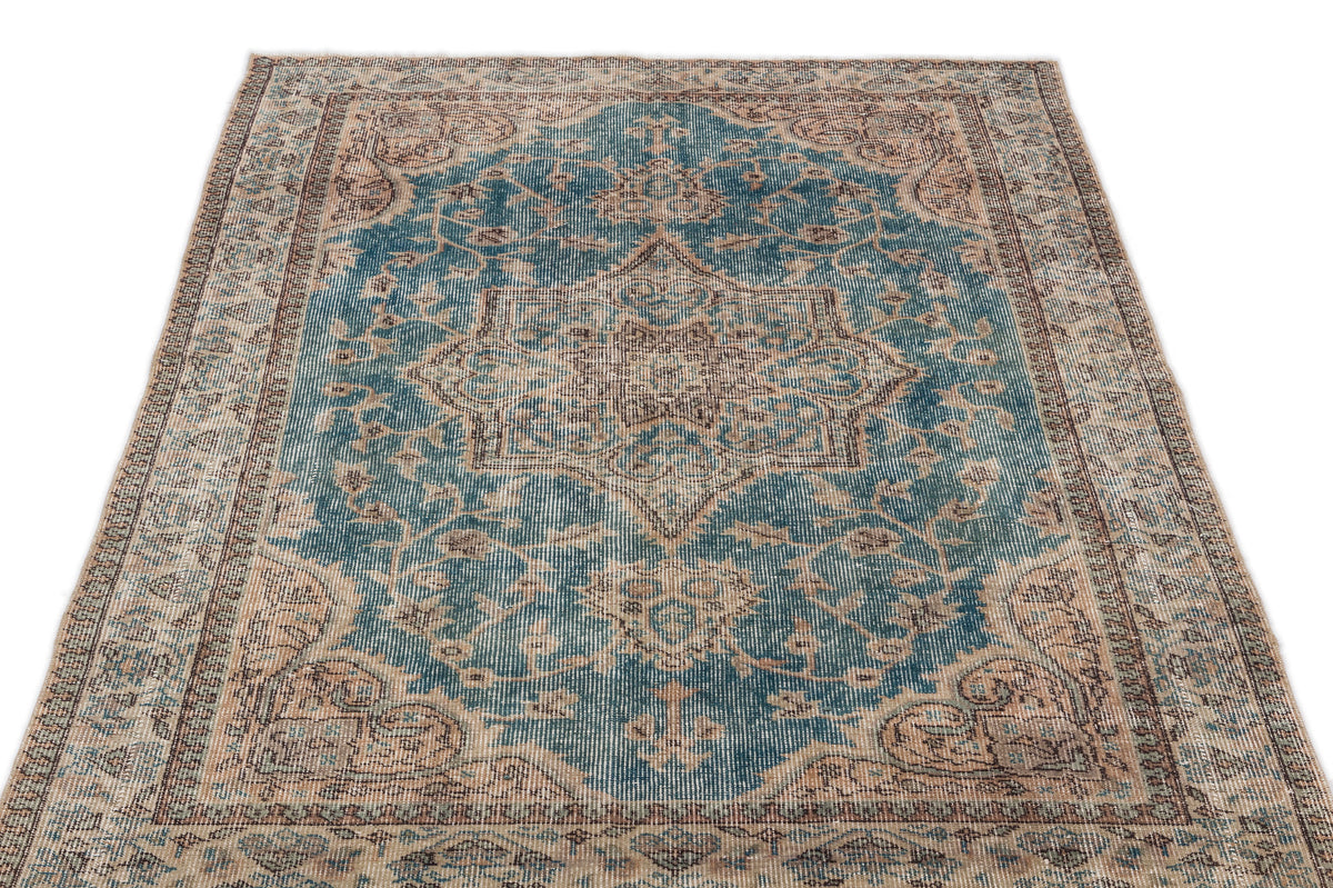 Teal and beige vintage-style rug with a central floral medallion and intricate border pattern on a white background.