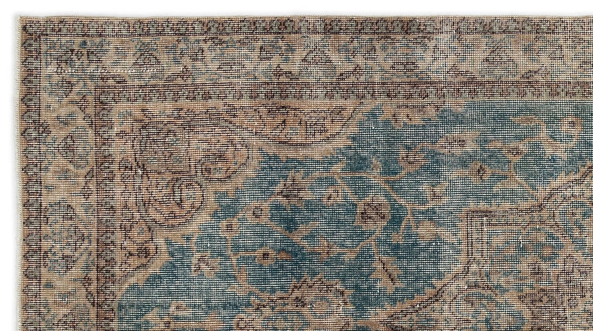 Distressed blue and beige traditional rug with an intricate floral medallion pattern and a detailed border.