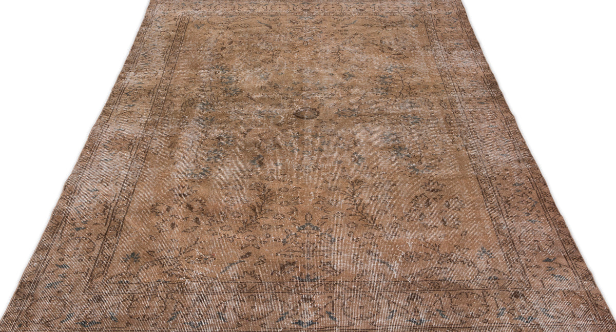 Distressed brown and grey vintage-style rug with a faded floral medallion pattern on a white background.