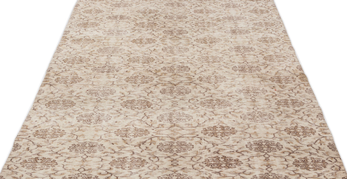 Beige and brown distressed rug with a repeating floral medallion pattern on a white background.