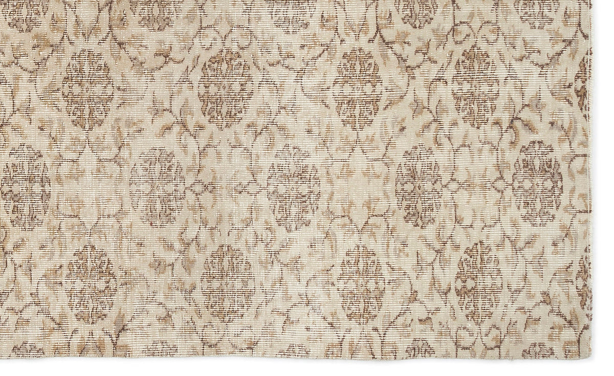 Beige and taupe rug with a distressed, repeating floral medallion pattern.