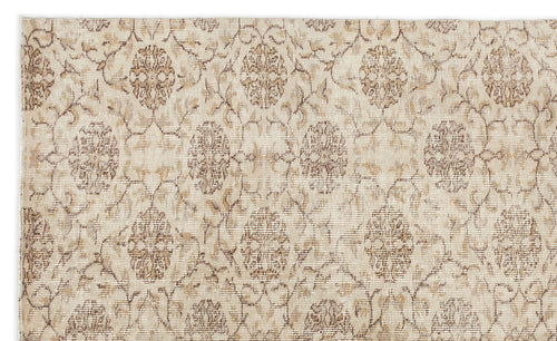 Load image 1 in gallery view. Beige and tan traditional rug with a repeating distressed floral medallion pattern.