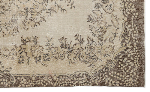 Load image 1 in gallery view. A close-up of the Petida - Vintage Medallion Rug (5'8 X 9'5) showcases its beige and brown tones, intricate floral and vine patterns, and slightly faded, distressed look for a timeless vintage appeal.