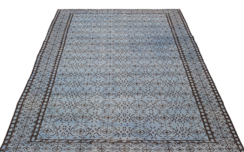 Load image 1 in gallery view. Light blue and dark brown distressed rug with a repeating geometric medallion pattern and a wide decorative border.