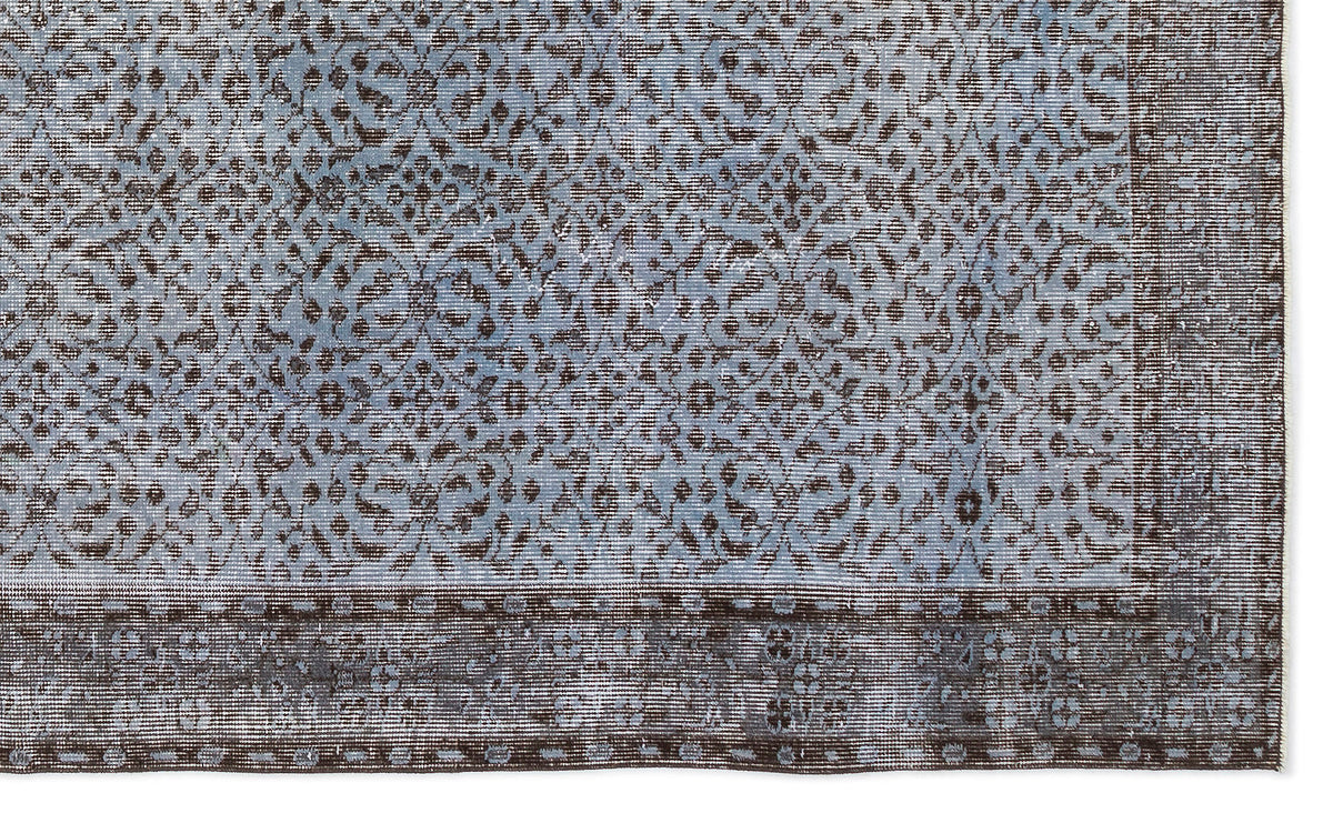 Blue and dark brown rug with a distressed traditional floral medallion pattern and a wide decorative border.