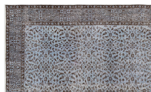 Load image 1 in gallery view. Distressed brown and light blue rug with a traditional floral medallion pattern and a wide decorative border.