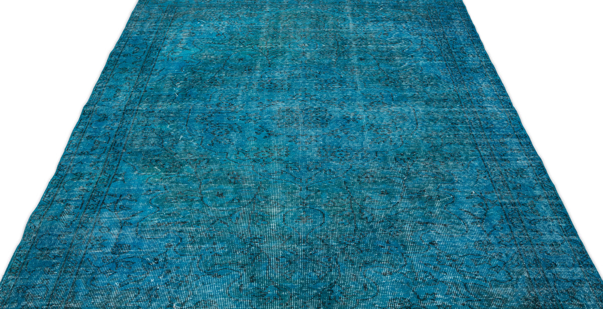 Teal distressed rug with a faded traditional floral medallion pattern on a white background.