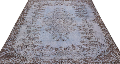 Load image 1 in gallery view. Light blue and brown distressed rug with a central floral medallion and ornate border pattern on a white background.