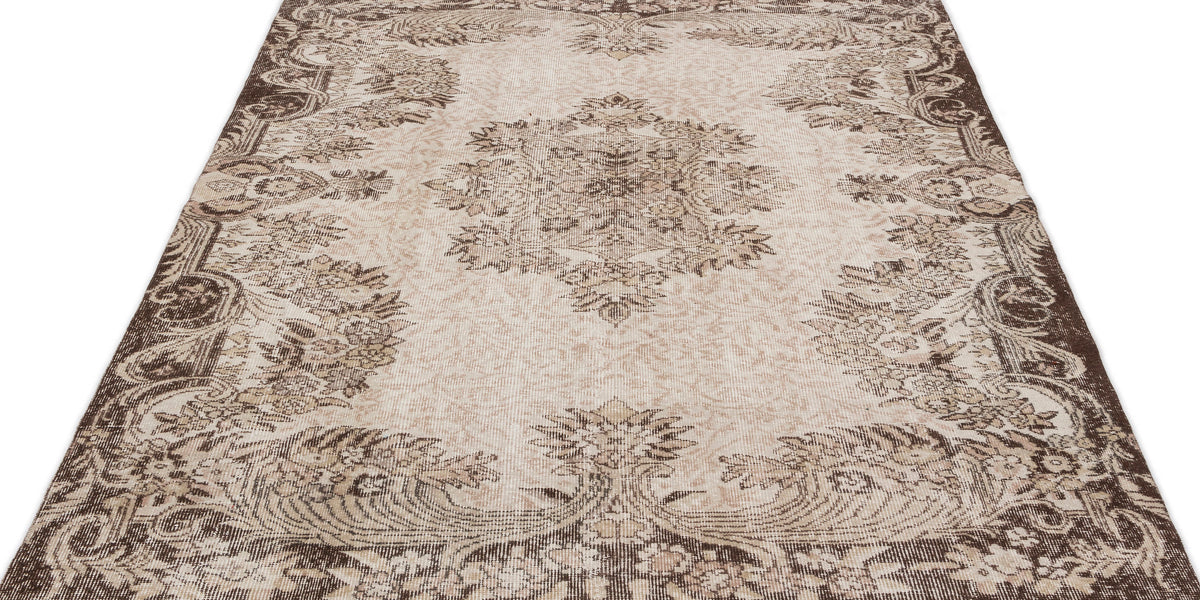 Beige and brown vintage-style rug with a central floral medallion and ornate border on a white background.