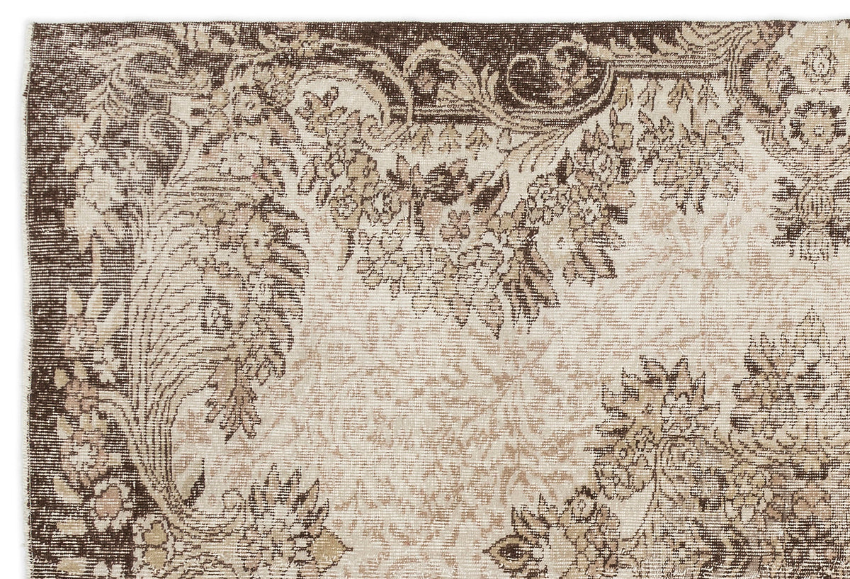 Brown and beige rug with a distressed traditional floral medallion pattern and ornate border.