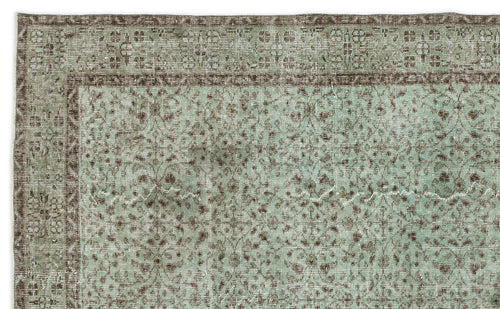 Load image 1 in gallery view. Sage green and brown vintage-style rug with a distressed floral medallion pattern and a decorative border.