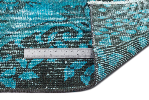 Load image 1 in gallery view. Teal and black distressed floral rug showing the pile and woven backing with a metal ruler for scale.