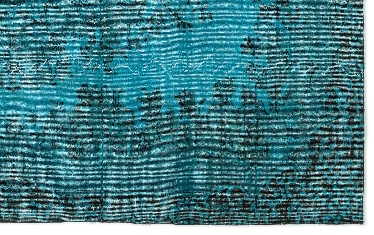 Teal and black distressed rug with a traditional floral medallion pattern on a white background.