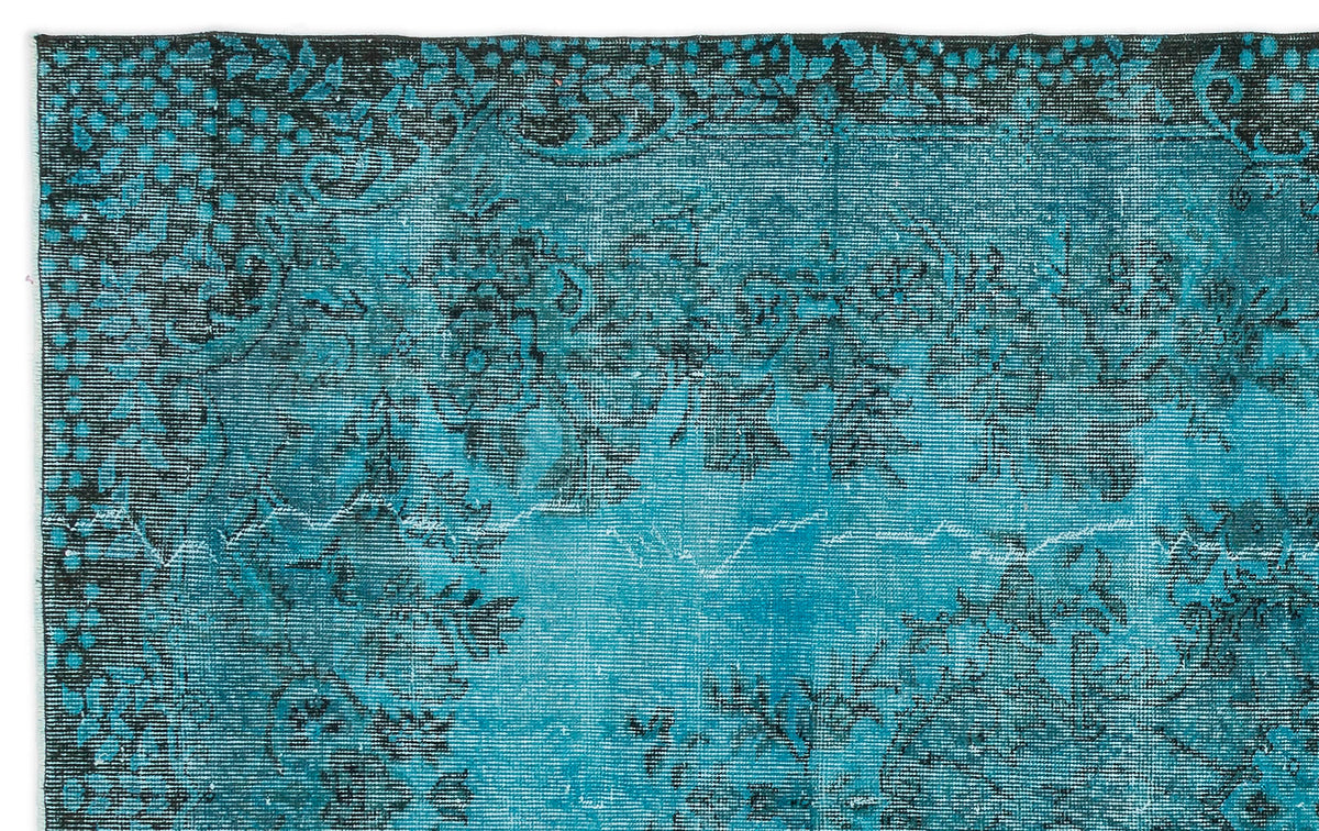 Teal and black distressed rug with a traditional floral medallion pattern.