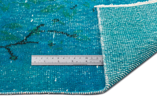 Load image 1 in gallery view. Teal distressed rug with a dark abstract pattern, shown with a metal ruler for scale and a folded corner.