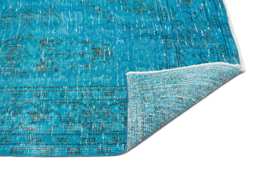 Load image 1 in gallery view. Bright turquoise distressed rug with a faded dark grey traditional medallion pattern, shown with a folded corner.