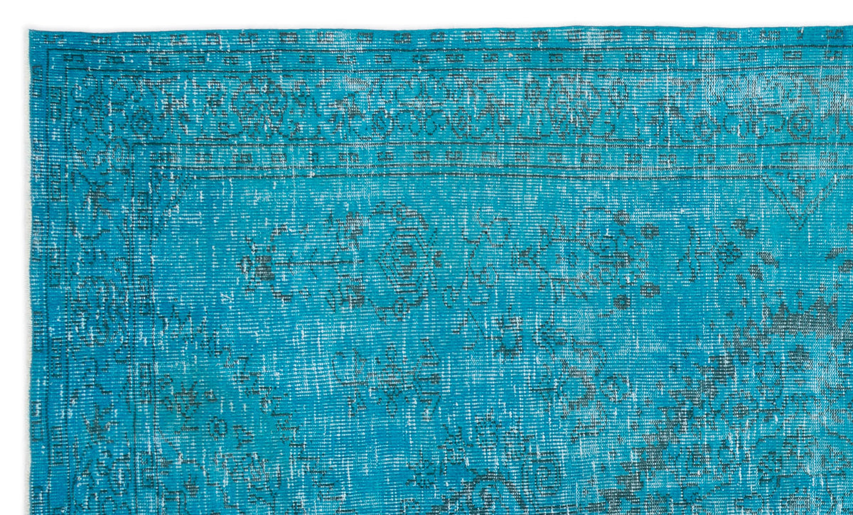 Bright turquoise rug with a distressed, faded traditional medallion pattern and a dark geometric border.