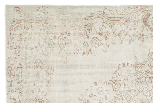 Load image 1 in gallery view. Cream rug with a faded, light brown floral medallion pattern on a white background.