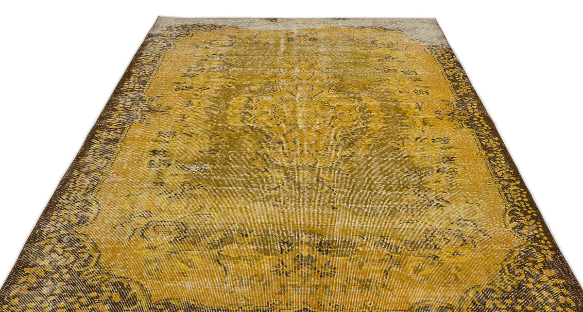 Mustard yellow and brown distressed rug with a traditional central medallion and ornate border on a white background.