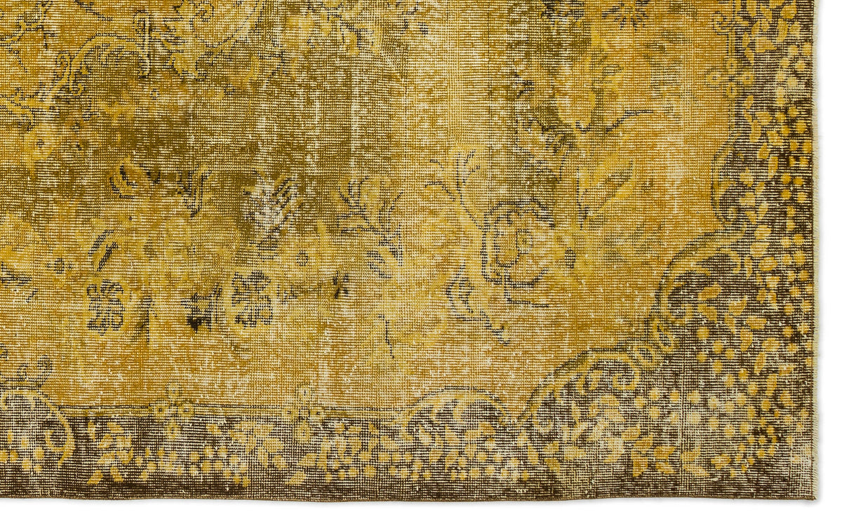 Distressed mustard yellow and brown rug with a faded traditional floral medallion pattern.