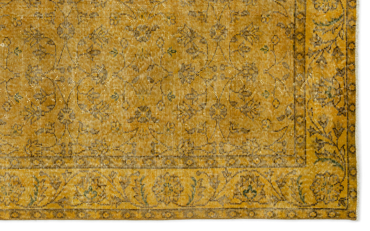 Mustard yellow vintage-style rug with a distressed floral pattern and a decorative border.