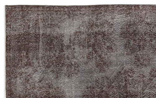 Load image 1 in gallery view. Dark brown and grey distressed vintage-style rug with a faded, abstract floral pattern.