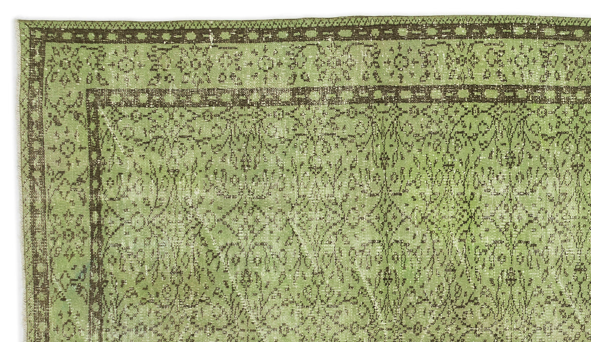 Sage green and dark brown vintage-style rug with a distressed floral medallion border and intricate central pattern.