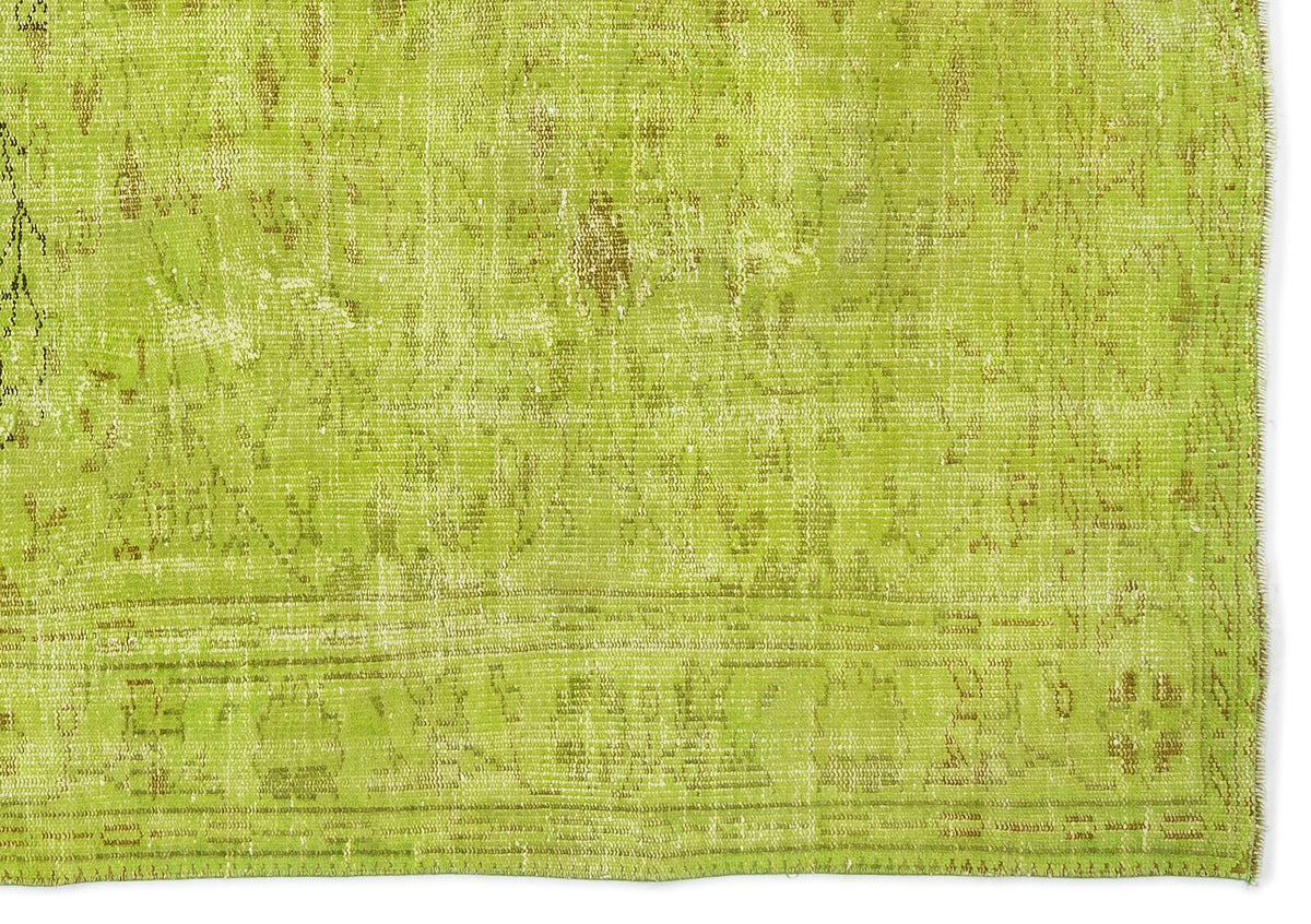 Chartreuse and olive green distressed rug with a faded traditional medallion pattern.