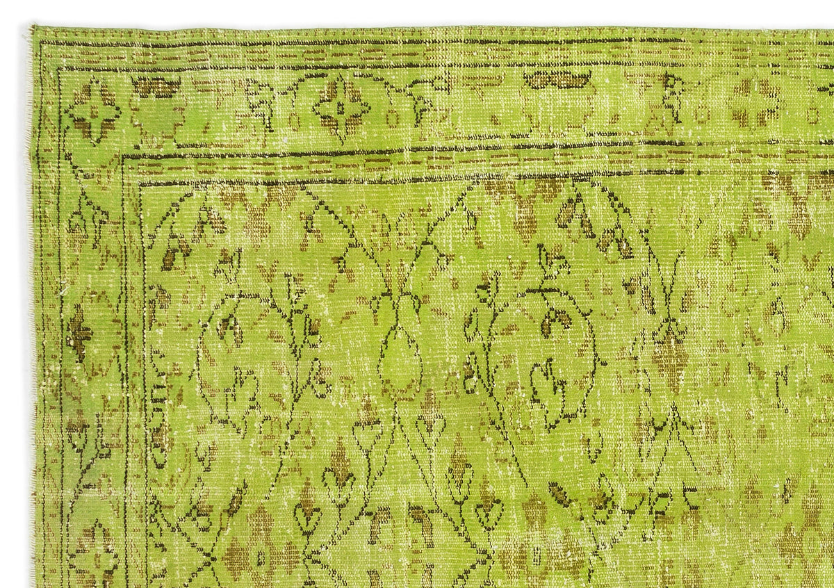 Chartreuse and brown distressed vintage-style rug with a traditional floral medallion border and central vine pattern.