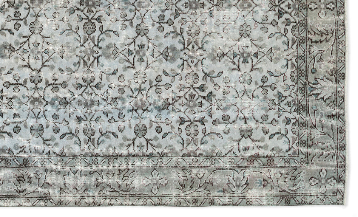 Light blue and grey traditional rug with a distressed floral medallion pattern and a decorative border.