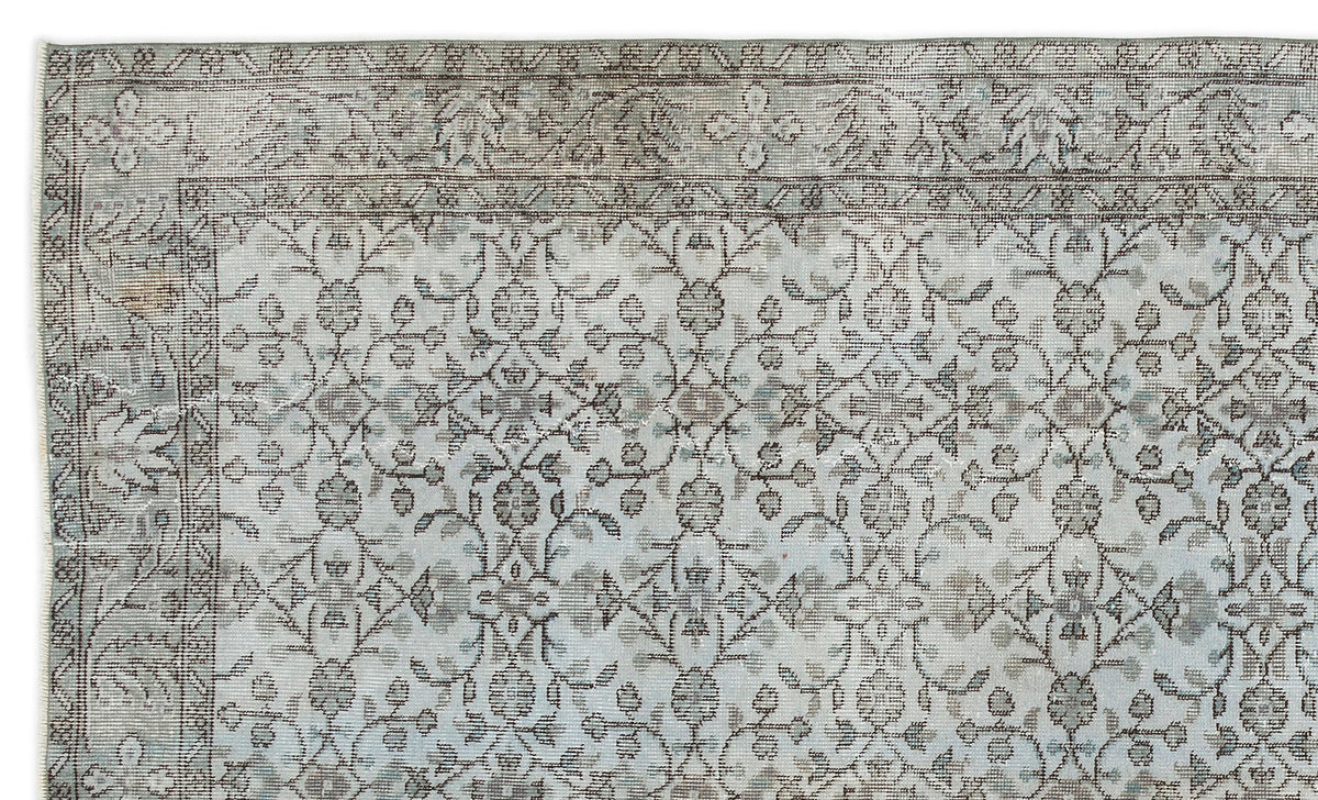 Light blue and grey vintage-style rug with a distressed floral medallion pattern and a detailed border.