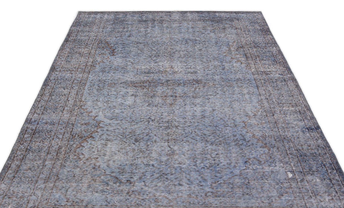 Blue and grey distressed vintage-style rug with a faded traditional floral pattern on a white background.