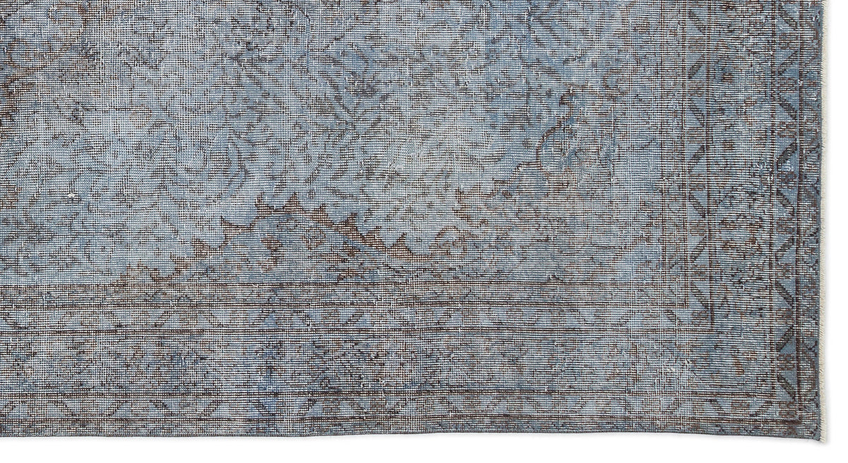 Blue and charcoal grey distressed rug with a traditional medallion pattern and a geometric border.