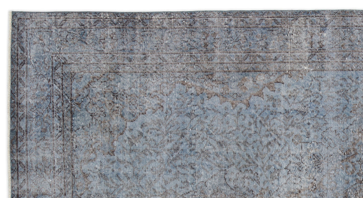 Blue and charcoal grey distressed rug with a faded traditional medallion pattern on a white background.
