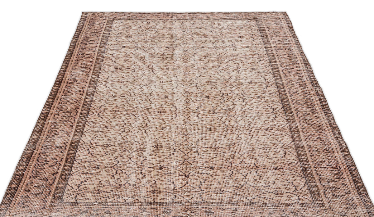 Beige and brown traditional area rug with a distressed, intricate floral pattern and a wide decorative border.