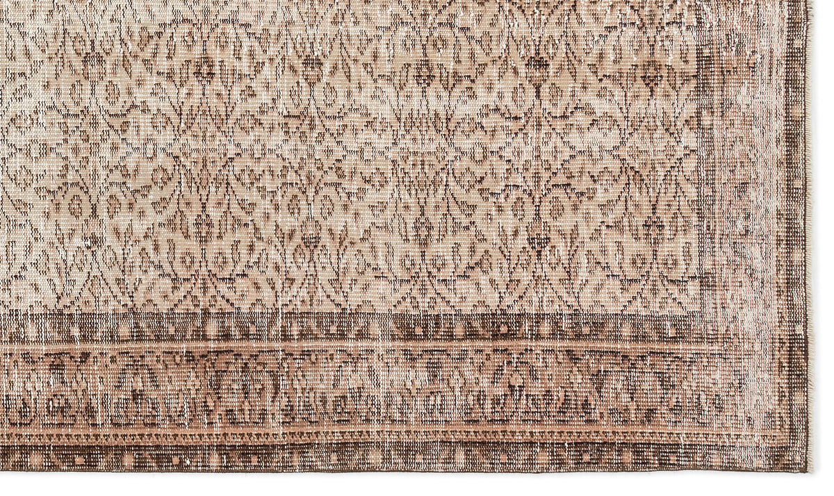 Beige and brown vintage-style rug with a distressed floral medallion pattern and a wide decorative border.