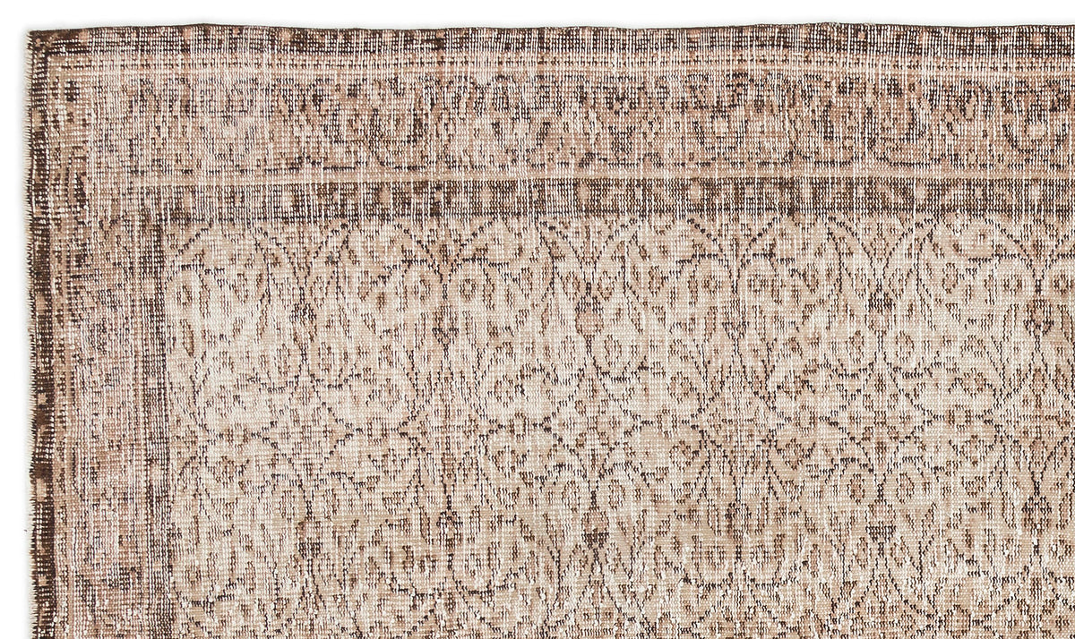 Beige and brown vintage-style rug with a distressed floral medallion pattern and a decorative border.