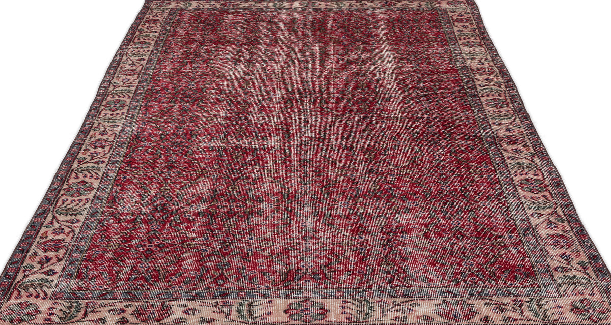 Distressed red and cream traditional rug with an intricate floral medallion pattern and a wide decorative border.