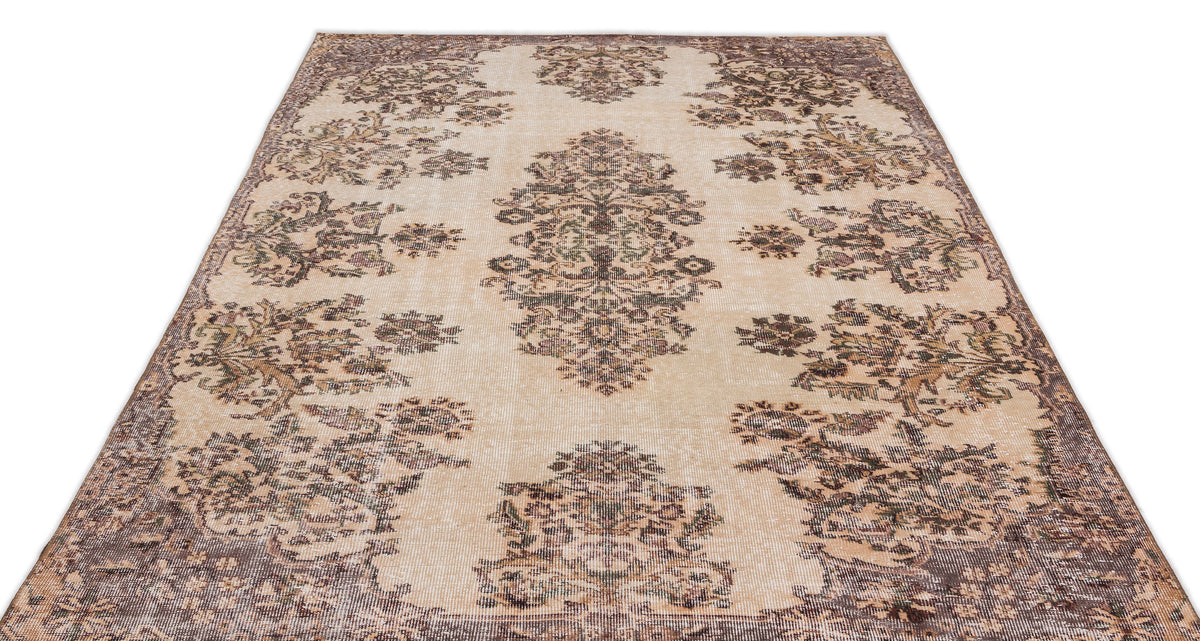 The Detiar Vintage Medallion Rug (5'9" x 9'5") features a beige flatwoven background with intricate floral patterns in brown, green, and gray, showcasing a symmetrical vintage design inspired by classic Anatolian heritage rugs.