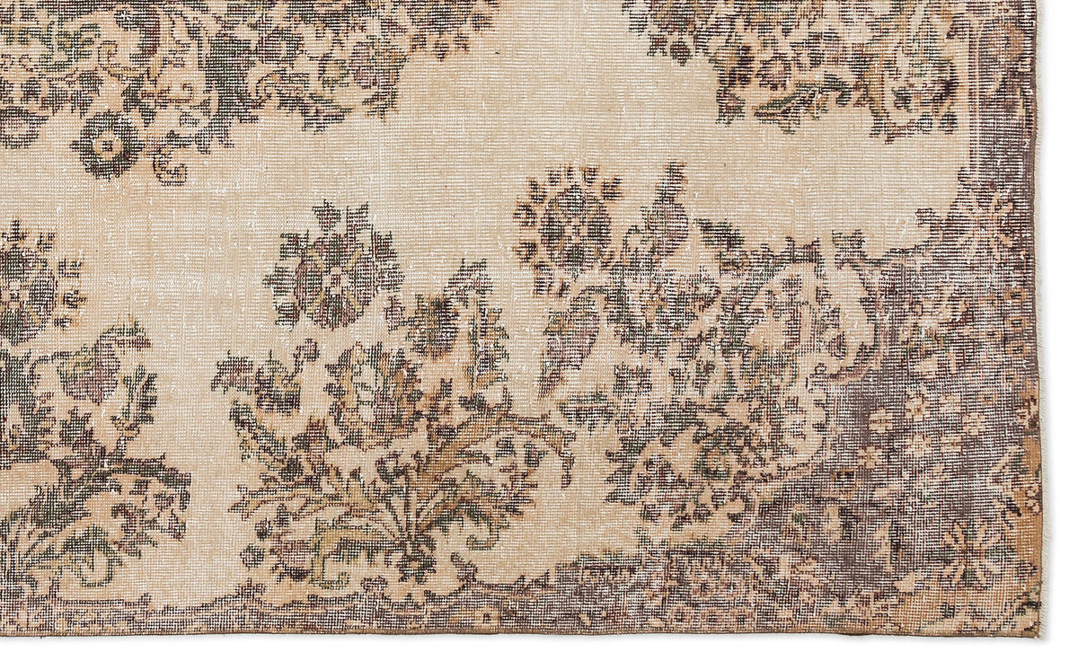 A close-up of the Detiar Vintage Medallion Rug (5'9" x 9'5") shows its vintage-style, flatwoven texture, faded floral pattern in brown, beige, and gray, and Anatolian-inspired symmetrical motifs with scattered border flowers.