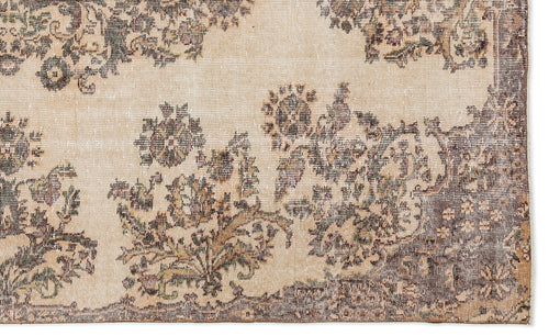Load image 1 in gallery view. A close-up of the Detiar Vintage Medallion Rug (5'9" x 9'5") shows its vintage-style, flatwoven texture, faded floral pattern in brown, beige, and gray, and Anatolian-inspired symmetrical motifs with scattered border flowers.