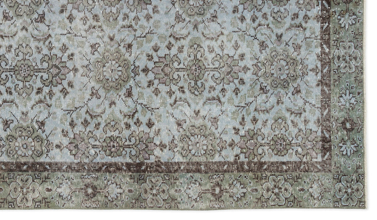 Light blue and sage green traditional rug with a distressed floral medallion pattern and a dark brown border.