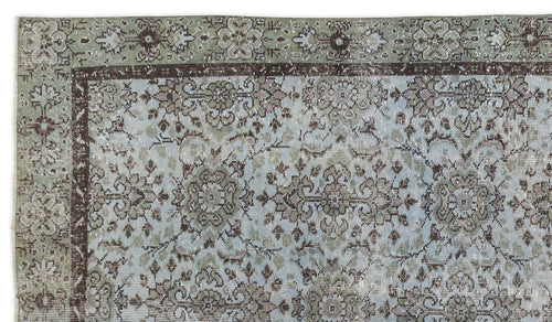 Load image 1 in gallery view. Distressed sage green and light blue rug with a dark brown floral medallion pattern and a decorative border.