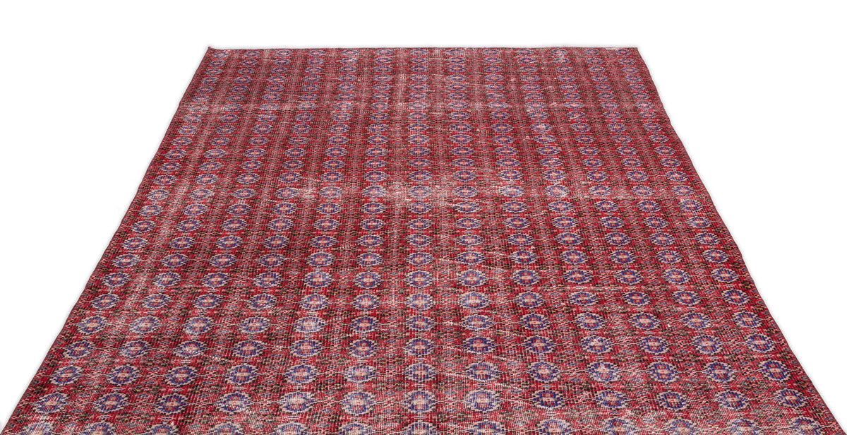Red and blue distressed rug with a repeating geometric medallion pattern on a white background.