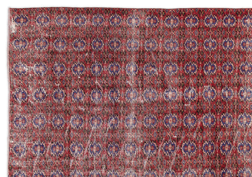 Load image 1 in gallery view. Distressed red rug with a repeating blue and beige geometric medallion pattern.
