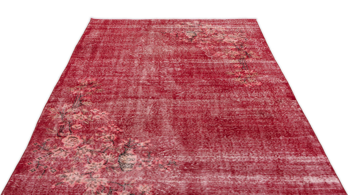 Distressed red rug with a faded floral pattern and white highlights on a white background.