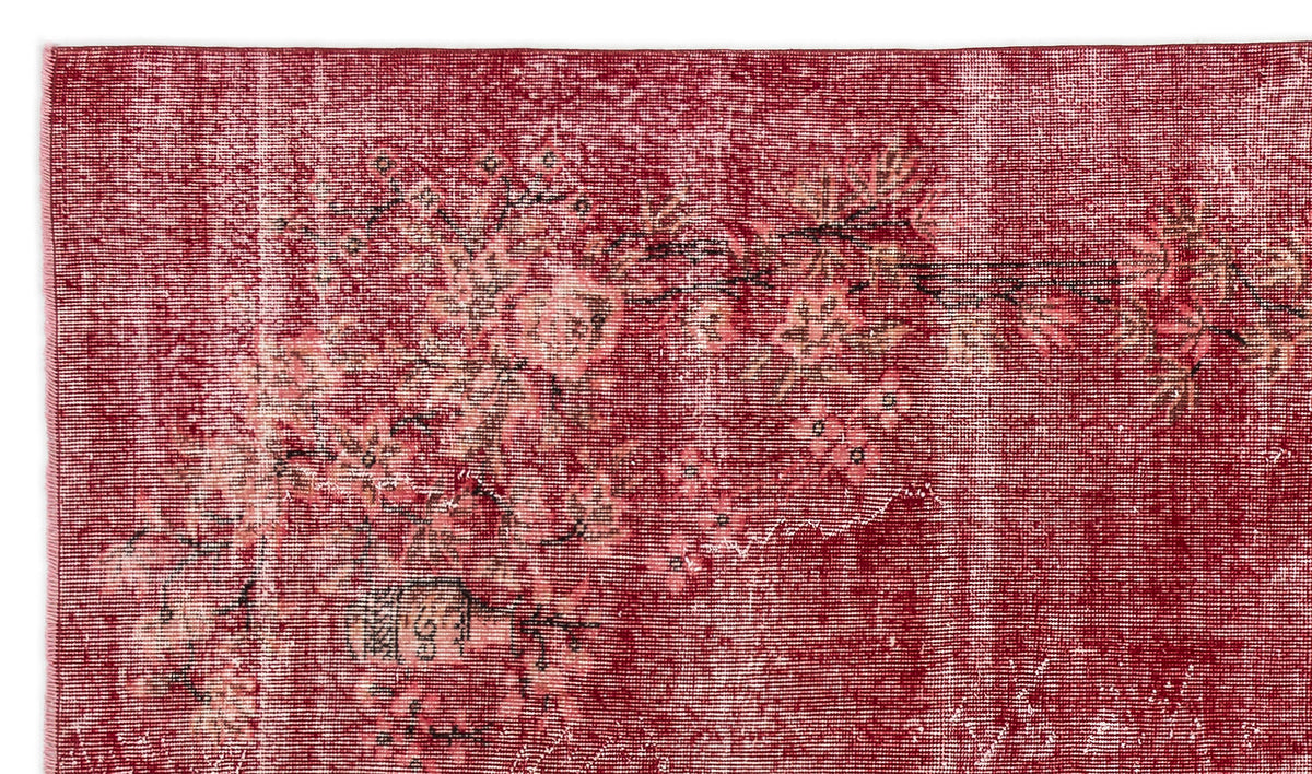 Deep red vintage-style rug with a distressed floral pattern and faded white accents.