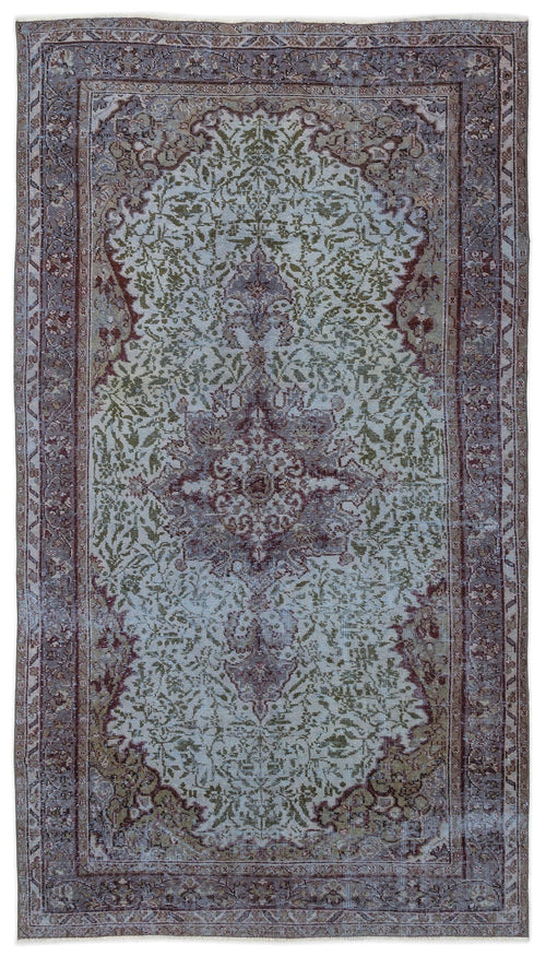 Load image 1 in gallery view. Distressed vintage-style rug with a central medallion and floral motifs in muted sage green, mauve, and cream.