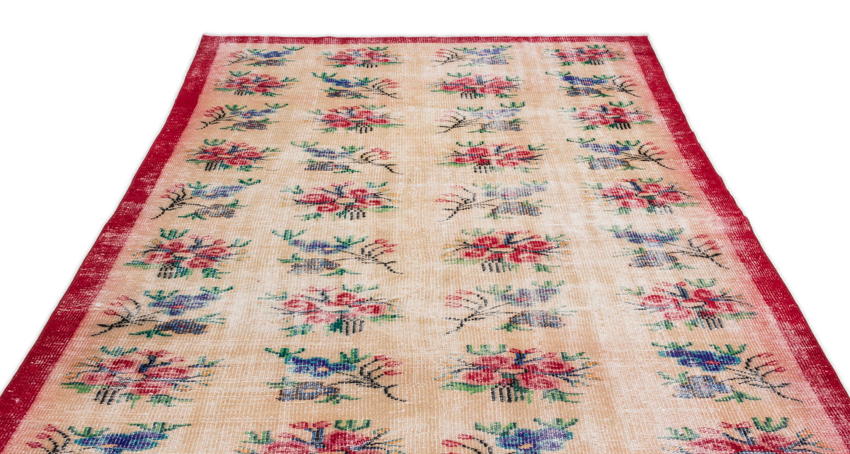 Beige vintage-style rug with a red border and repeating floral motifs in red, blue, and green.