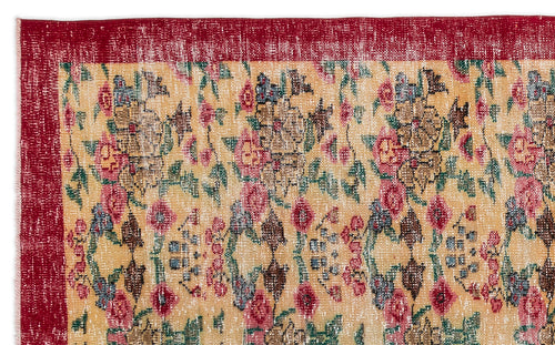 Load image 1 in gallery view. Distressed beige rug with a red border and a repeating floral pattern in red, green, and blue.